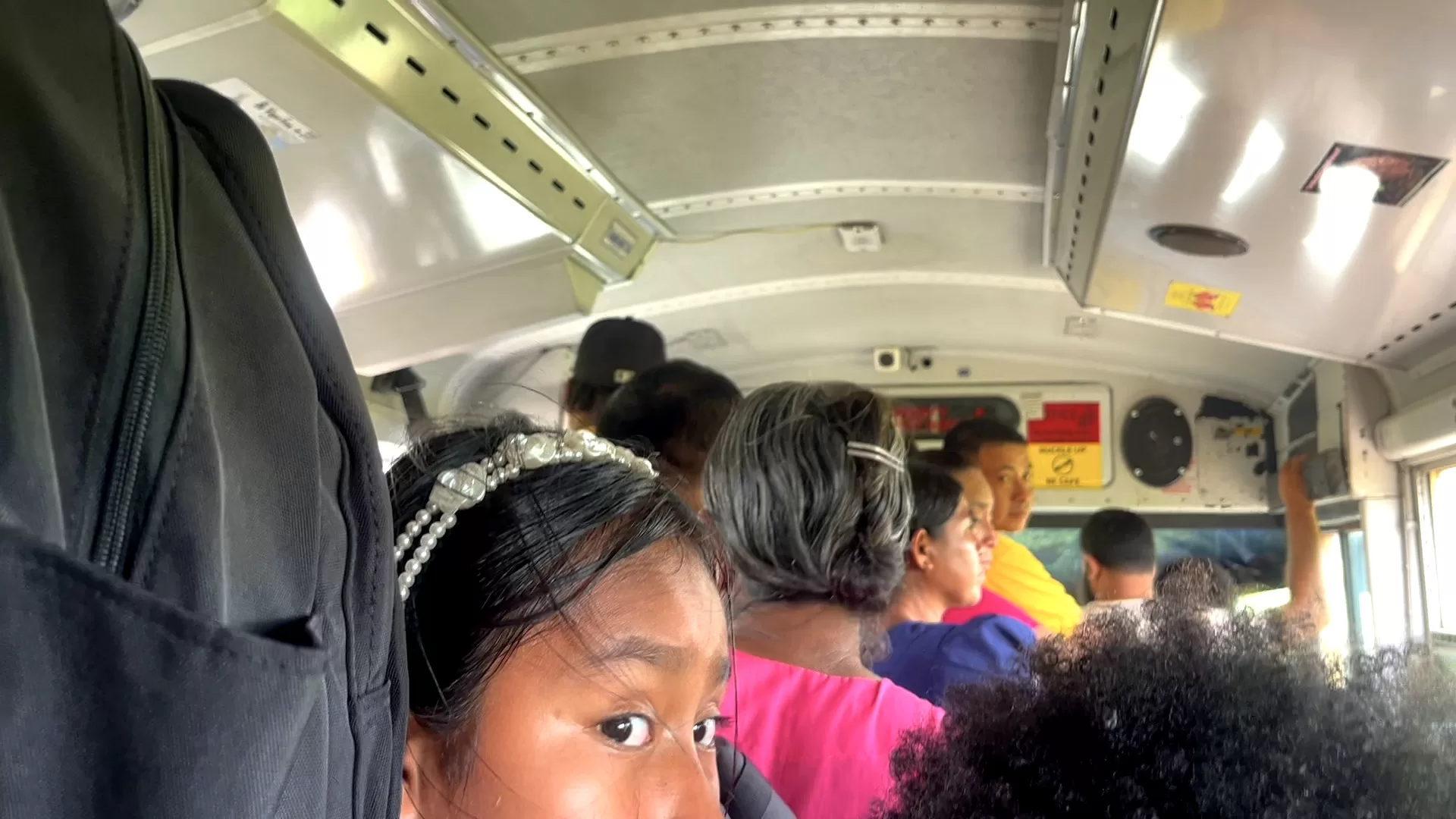 people standing all the way to the door in a bus.